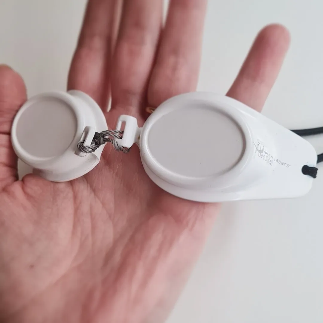 Gafas de protección para la sesión de depilación láser, en la mano de la Dra. Cintia Bello